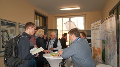 Menschen im Gespräch an einem Messestand