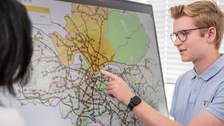Studierende vor einem Verkehrsplan