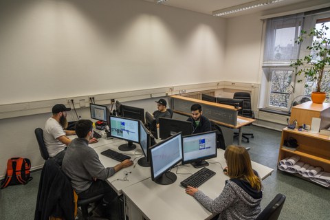 Gruppe von Studierenden mit Computern bei der Projektarbeit