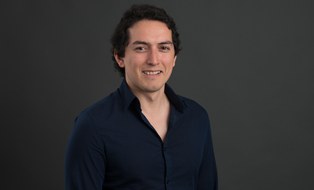 Here is a photo of Eduardo Alarcon. He smiles.