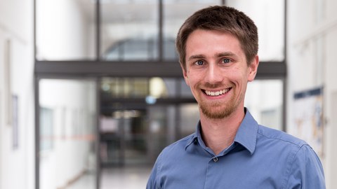 Hier ist ein Bild von Janis Neufeld. Er lächelt.