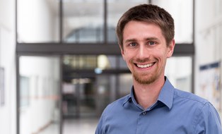 Hier ist ein Bild von Janis Neufeld. Er lächelt.