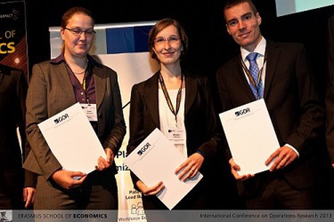 Two women and one man with documents in their hands. 
