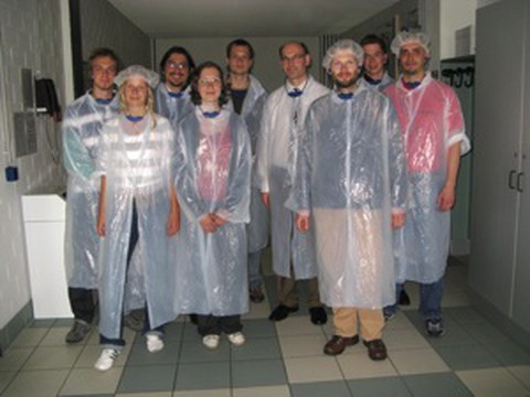 Exkursionsteam mit weißer Schutzkleidung.
