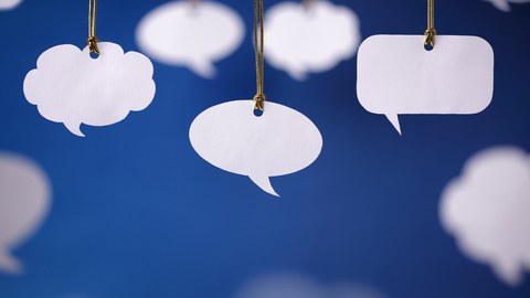 Das Bild zeigt drei verschiedene weiße Sprechblasen auf blauem Hintergrund. 
