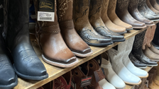 Zu sehen ist ein Schuregal mit Cowboystiefeln