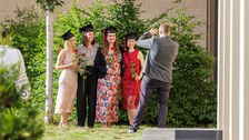 Es sind vier Absolventinnen zu sehen, die gerade fotografiert werden  