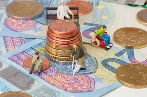 Zu sehen sind Geld und alte Menschen. Das soll den Sozialstaat symbolisieren, der sich im Ungleichgewicht befindet.
