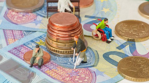 Zu sehen sind Geld und alte Menschen. Das soll den Sozialstaat symbolisieren, der sich im Ungleichgewicht befindet.