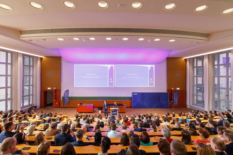 Man sieht den Schönfeld-Hörsaal, der voller Menschen ist