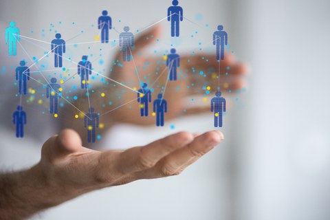 zu sehen ist eine Grafik, bei der viele Personen über Netze miteinander verbunden sind