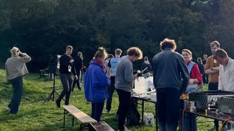 Man sieht viele Mitglieder des FSR an einem Grill