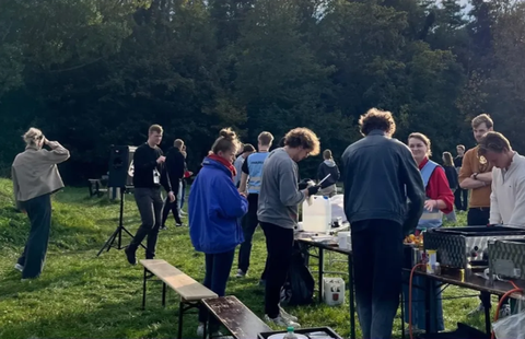 Man sieht viele Mitglieder des FSR an einem Grill