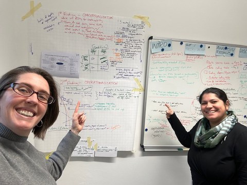 Man sieht Beth Embry zusammen mit Samanthi Dijkstra-Silva vor eine Wand mit vielen Notizen