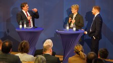Die Podiumsdiskussion startet mit Veronika Grimm und Michael Kretschmer und wird von Prof. Leßmann moderiert.