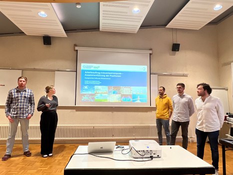Es sind Studierende bei einer Präsentation in einem Seminarraum zu sehen. 