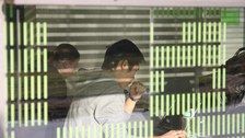 Das Bild zeigt Studierende hinter einer Glasscheibe, die an ihrem Laptop arbeiten.