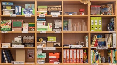 Das Foto zeigt eine Regalwand mit vielen Materialien zu verschiedenen Themen.