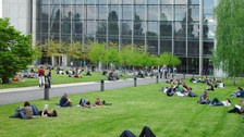 Rückseite des Hörsaalzentrum der TU Dresden. Auf der Wiese sieht man viele Studierende in kleinen Gruppen.
