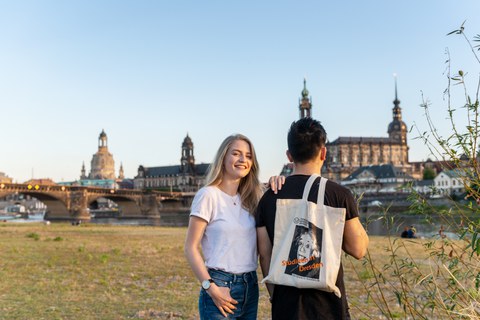  Ein Paar steht an den Elbwiesen mit der Elbe und der Altstadt Dresdens im Hintergrund