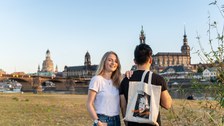  Ein Paar steht an den Elbwiesen mit der Elbe und der Altstadt Dresdens im Hintergrund