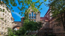 Innenhof des Tillich-Baus der TU Dresden. Dieser ist mit vielen Pflanzen und Bäumen bewachsen. Im Hintergrund erkennt man einen Torbogen.