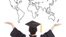 Das Foto zeigt eine Person von Hinten. Sie trägt einen Doktorhut und hebt die Arme nach oben. Über ihr erkennt man die Umrisse einer Weltkarte.