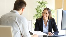 oto von zwei Personen, die sich in einem Vorstellungsgespräch gegenübersitzen und unterhalten.
