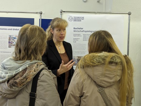 Man sieht eine Mitarbeiterin im Gespräch mit Studierenden.