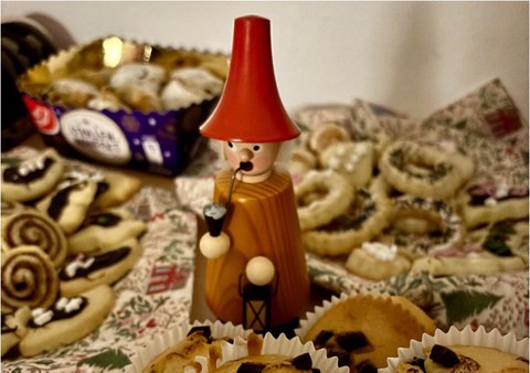 Ein Räuchermännchen umgeben von süßen Snacks