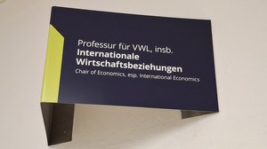 Foto des Lehrstuhlschildes der Professur Internationale Wirtschaftsbeziehungen im Treppenhauses des Hülße-Baus