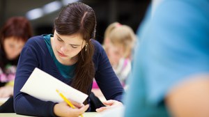 Es ist eine Studentin zu sehen, die gerade eine Prüfung schreibt
