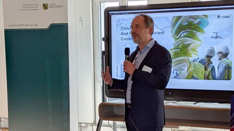Prof. Mechtcherine bei einer Präsentation spricht mit Mikrofon in der Hand
