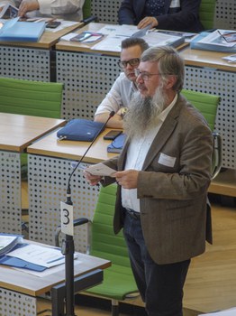 Teilnehmer aus dem Publik steht am Mikrofon