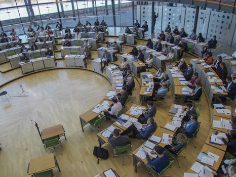 Teilnehmende sitzen im Plenarsaal 