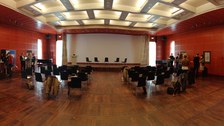 ein Panaromabild über den gesamten Saal. Personen stehen an Stehtischen und diskutieren.