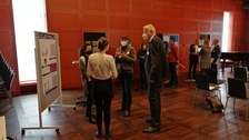 Personen stehen an Stehtischen und diskutieren