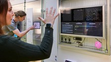 Eine Besucher:in bedient ein interaktives Ausstellungsstück