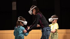 Foto von 2 Kindern und einer erwachsenen Person mit VR-Brillen 