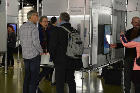 Zwei Gruppen von Teilnehmenden auf der Eröffung der DataSpaces-Ausstellung im Gespräch vor unterschiedlichen Exponaten.