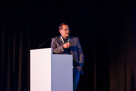 Foto. Prof. Dr. Christian Mayr präsentiert beim All Hands Meeting 2024.