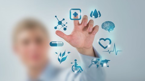 The photo shows a doctor’s hand operating a modern computer. Nine medical icons are displayed on the screen.