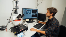 Scientist in front of fluorescence microscope