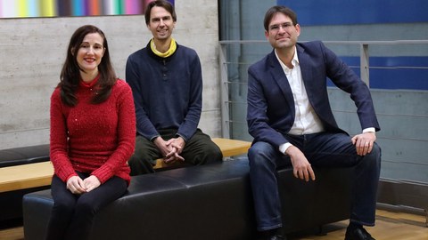 Three people sitting together and smiling