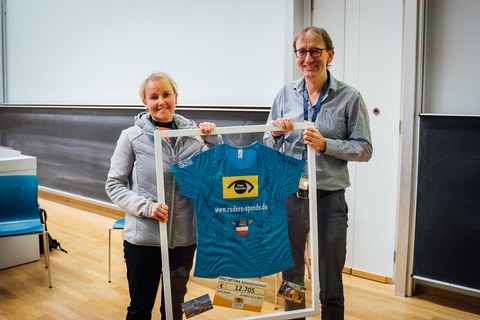 Prof. Dr. Marius Ader receiving the money collected throughout the rowing challenge 