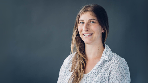 A photo. A portrait of a person against a gray background.