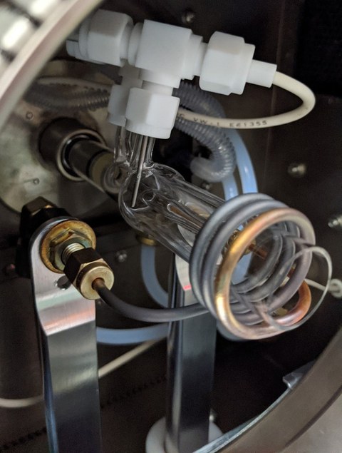 The picture shows the a part of the front door, with the metal RF Load coil around the glassy Torch Body, where the cells are vaporized