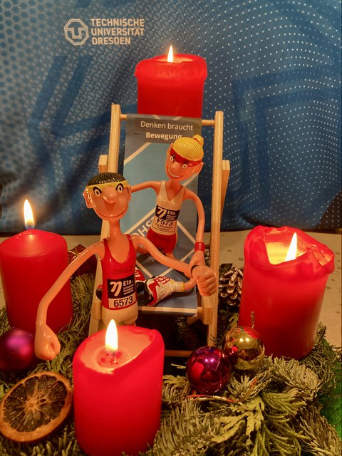 Foto 2 Puppen in Sportkleidung mit  Adventskranz mit 4 brennenden Kerzen