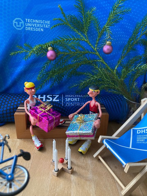 Foto zwei Puppen in Sportkleidung und Mund-Nasen-Bedeckung mit Weihnachtgeschenken