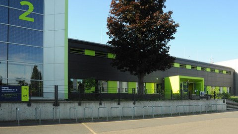 Foto Vorderfront einer Sporthalle mit grünen Elementen